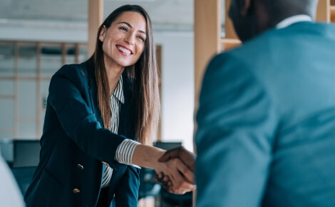 business woman shaking hands with someone out of frame